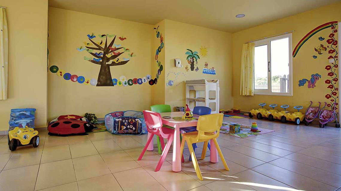 Kinderzimmer im Atlantica Marmari Palace mit bunten Wandmalereien, bunten Stühlen und Spielzeug.
