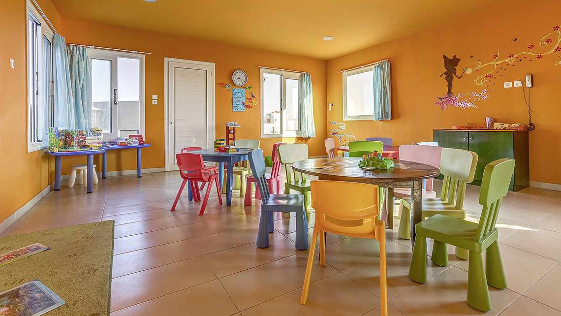 Kinderspielzimmer im Atlantica Marmari Palace mit bunten Tischen und Stühlen.