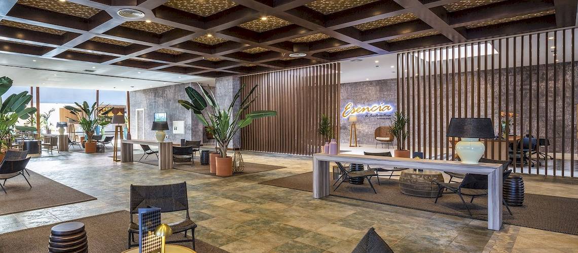 Lobby des Fuerteventura Princess Hotels mit vielen Pflanzen, Möbeln und einer Lampe.