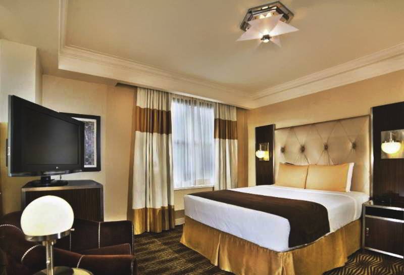 Hotelzimmer im New Yorker mit Fernseher, Bett und Nachttisch
