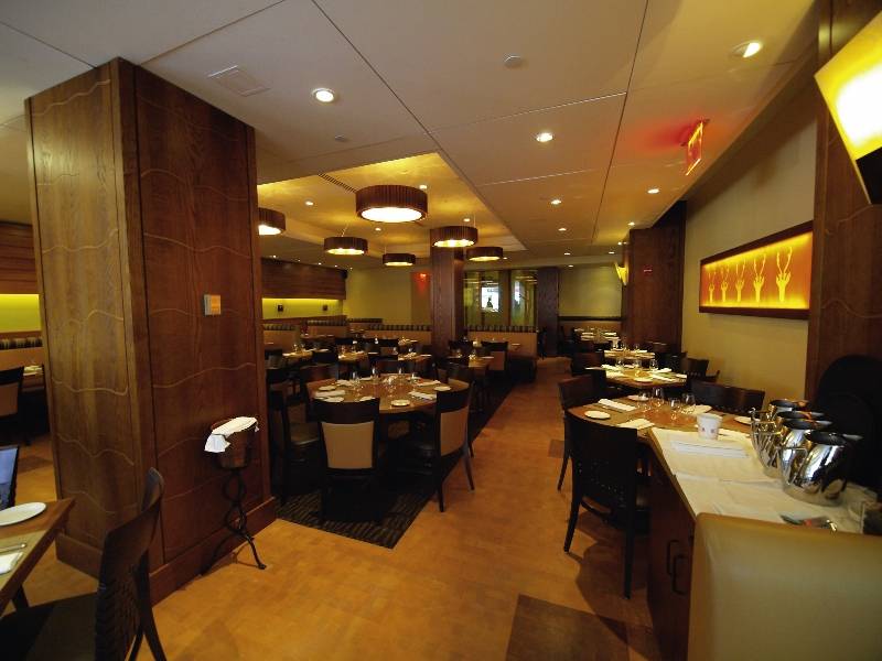 Innenansicht des New Yorker Restaurants mit geräumigen Tischen, Holzelementen und warmem Licht.