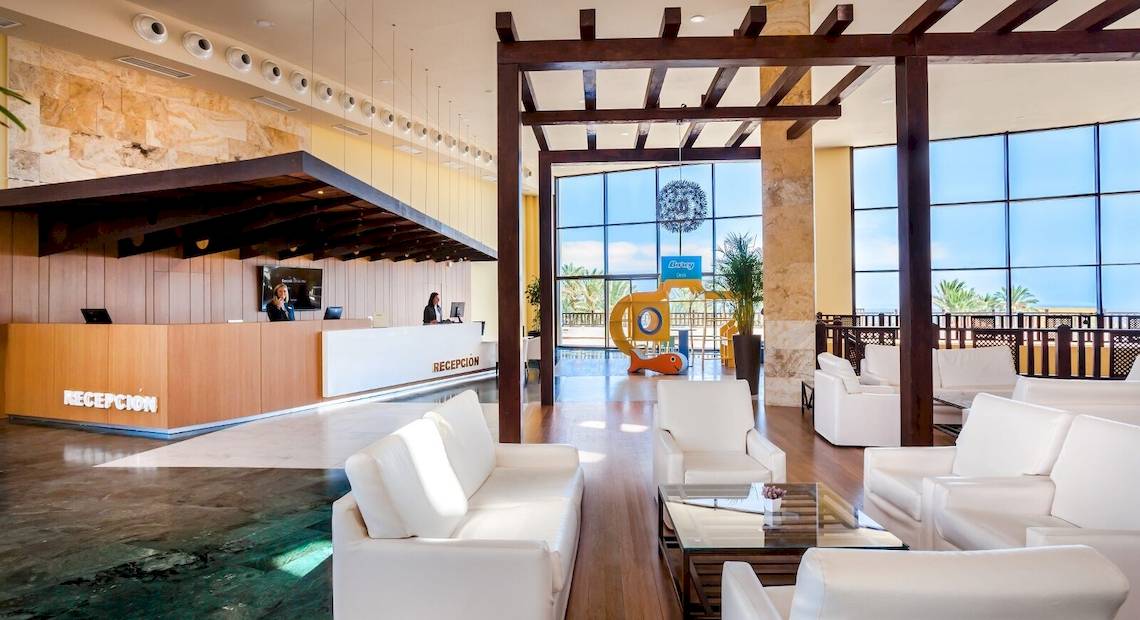 Empfangsbereich im Occidental Jandia Mar Hotel mit Rezeptionstresen und Loungestühlen.