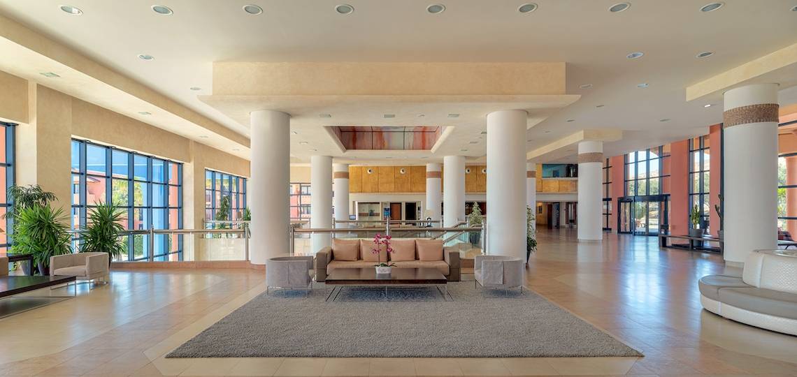 Empfangsbereich des H10 Tindaya Hotels mit Sofa, Couchtisch, Teppich und großen Fenstern.