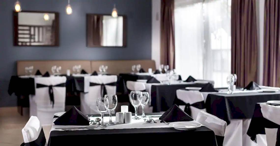 Restaurant-Innenbereich des Melia Tortuga Beach Hotels mit elegant gedeckten Tischen und Stühlen.
