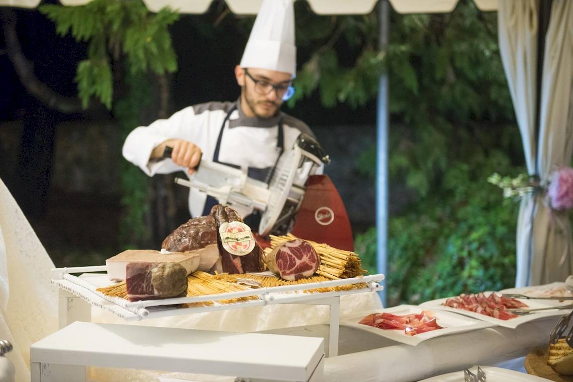 Koch im Sierra Silvana Hotel schneidet Fleisch für ein Buffet.