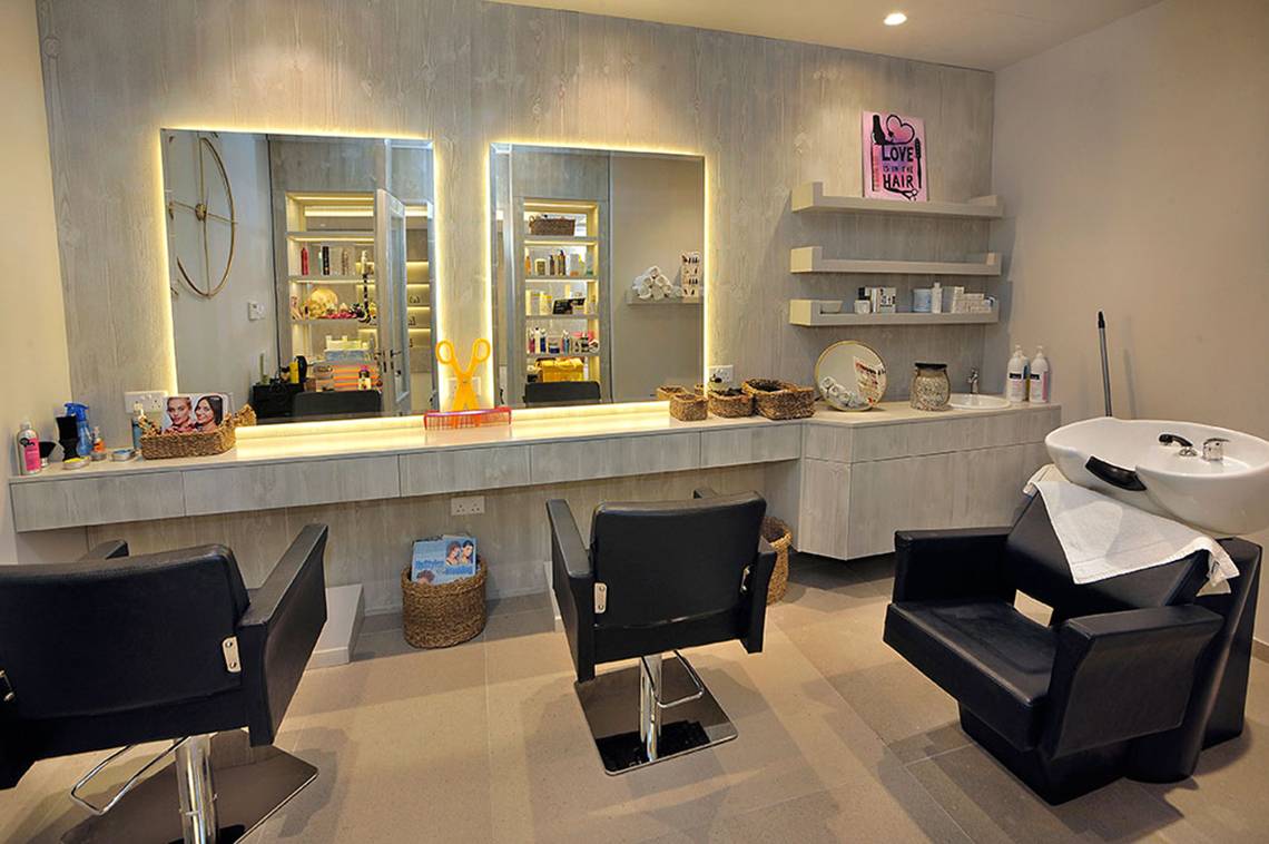 Friseursalon im Nelia Beach Hotel & Spa mit Spiegeln, Stühlen und Waschbecken.