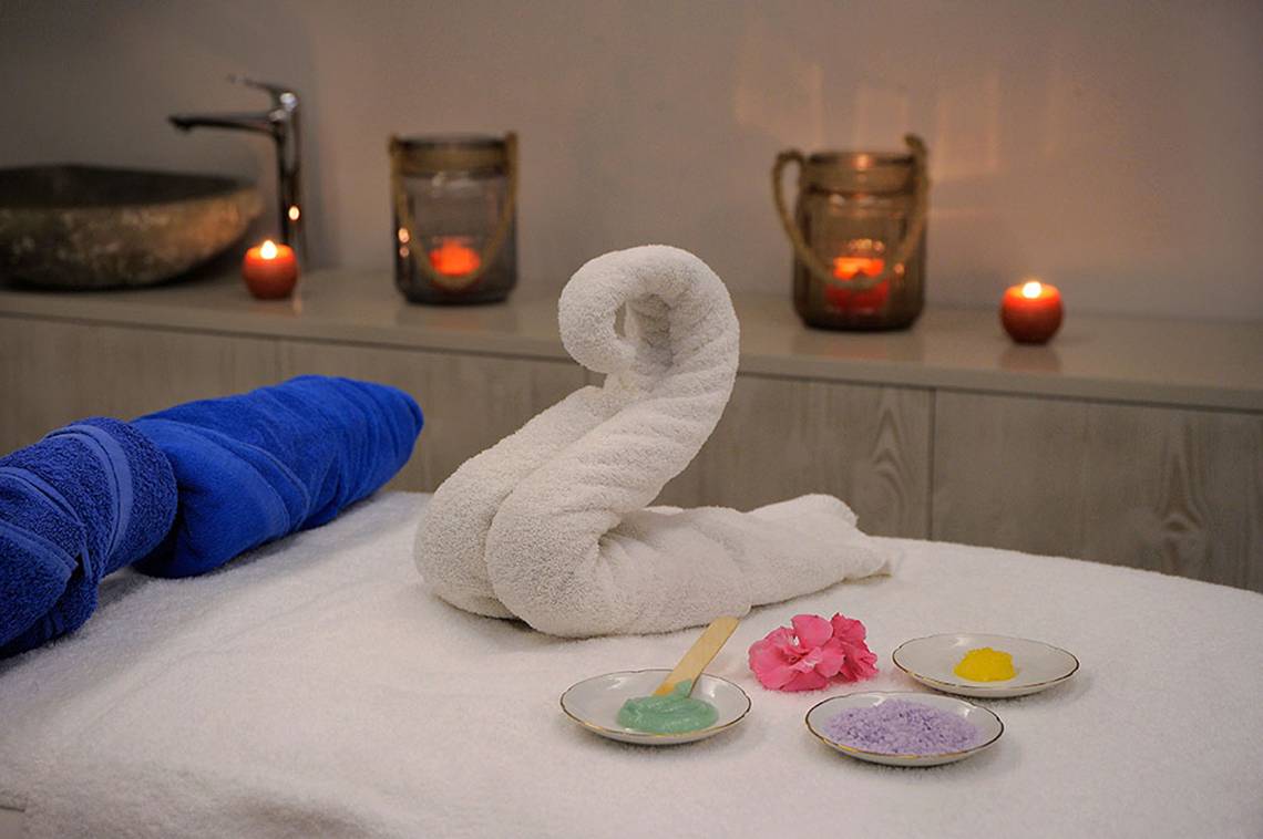 Massagetisch im Spa des Nelia Beach Hotel mit Handtüchern und Pflegeprodukten.