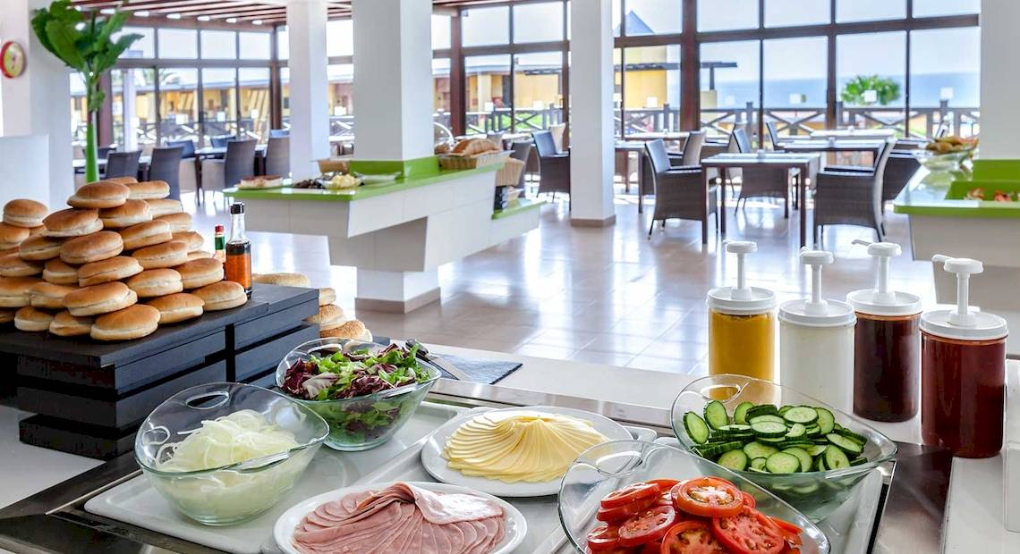 Buffet-Restaurant im Occidental Jandia Playa Hotel mit einer Auswahl an Salaten, Tomaten, Gurken, Schinken, Brot und Dressings.