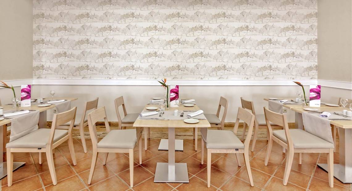 Innenansicht des Restaurants im Occidental Jandia Playa Hotel mit gemusterten Wänden und gedeckten Tischen.