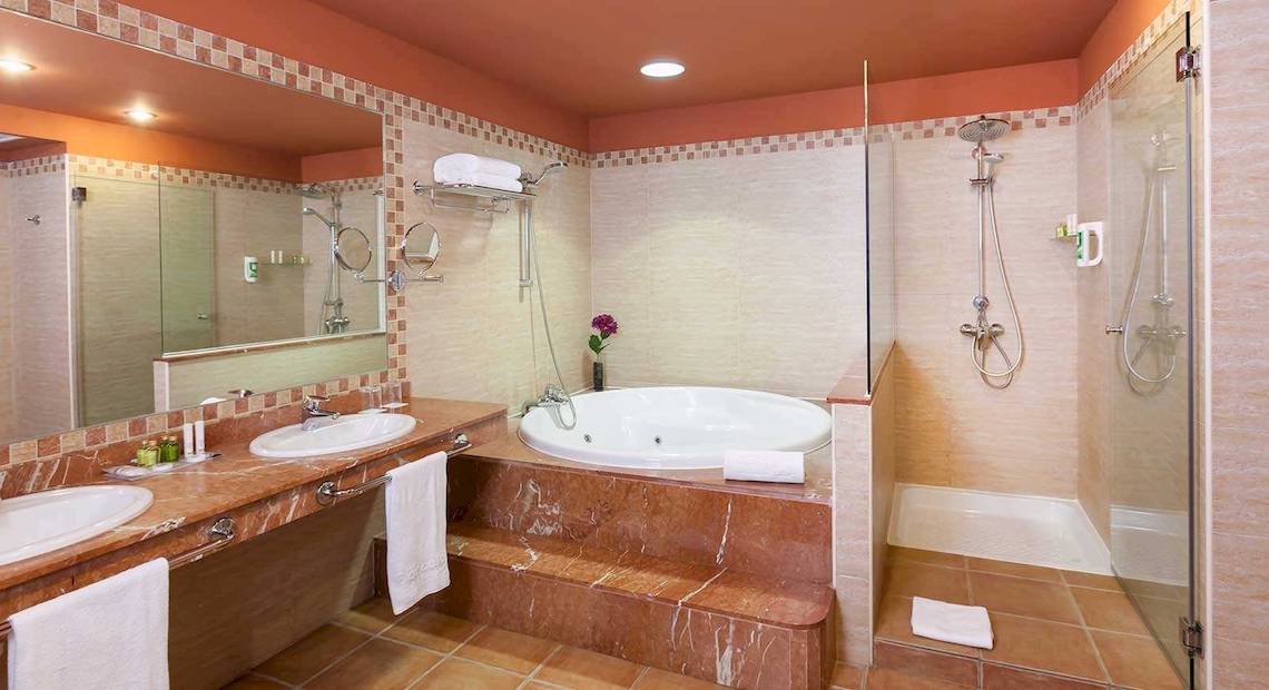 Badezimmer im Occidental Jandia Playa Hotel mit Badewanne, Dusche und Waschbecken.