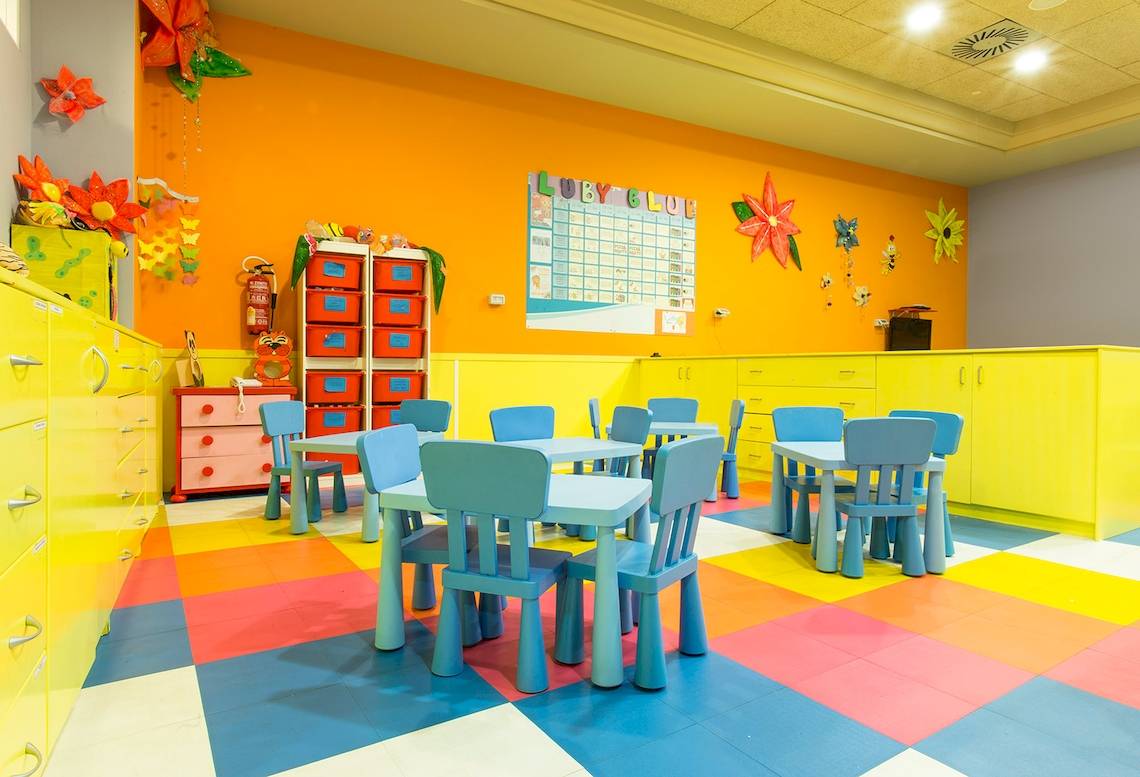 Foto von einem bunten Kinderzimmer im Landmar Costa Los Gigantes Hotel mit Tisch, Stühlen und dekorativen Wandelementen.
