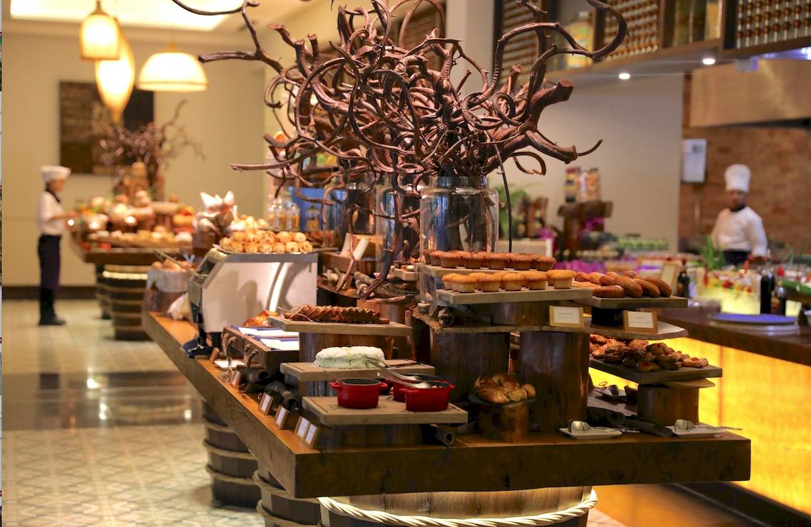 Buffet im Salinda Resort auf der Insel Phu Quoc mit verschiedenen Desserts und Angestellten im Hintergrund.