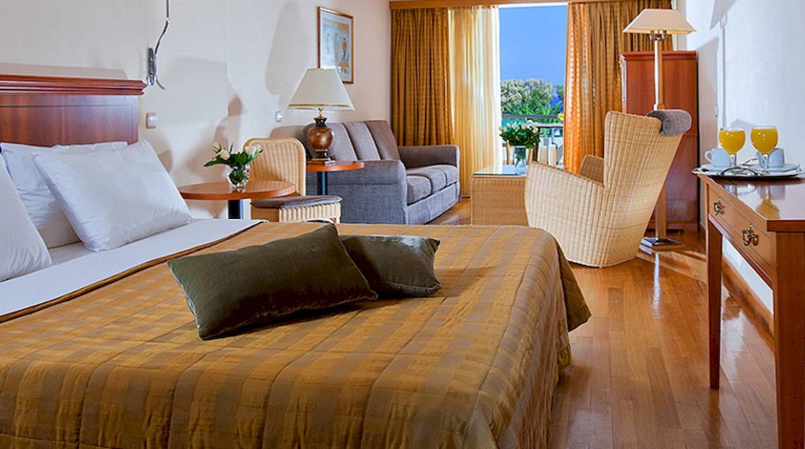 Hotelzimmer von Giannoulis Santa Marina Beach mit Bett, Sofa, Stühlen und Ausblick.