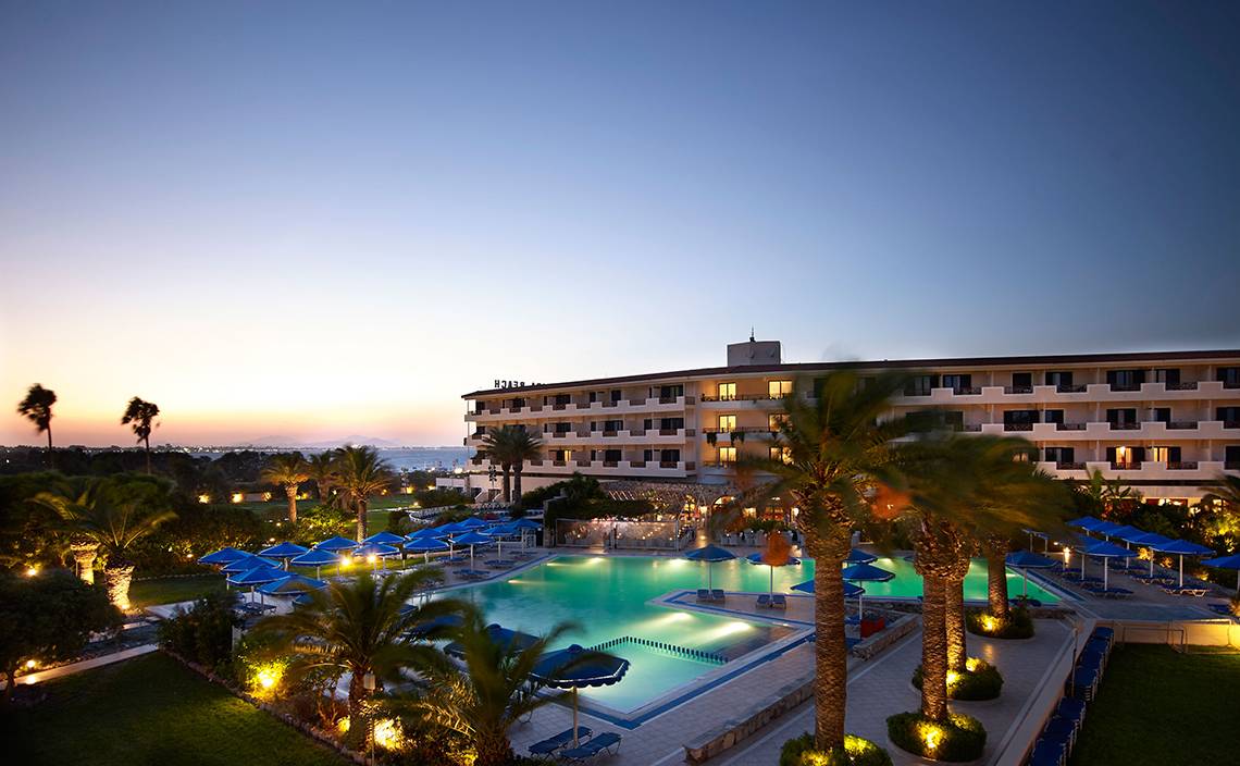 Außenbereich des Mitsis Ramira Beach Hotels mit Swimmingpool und Sonnenschirmen.