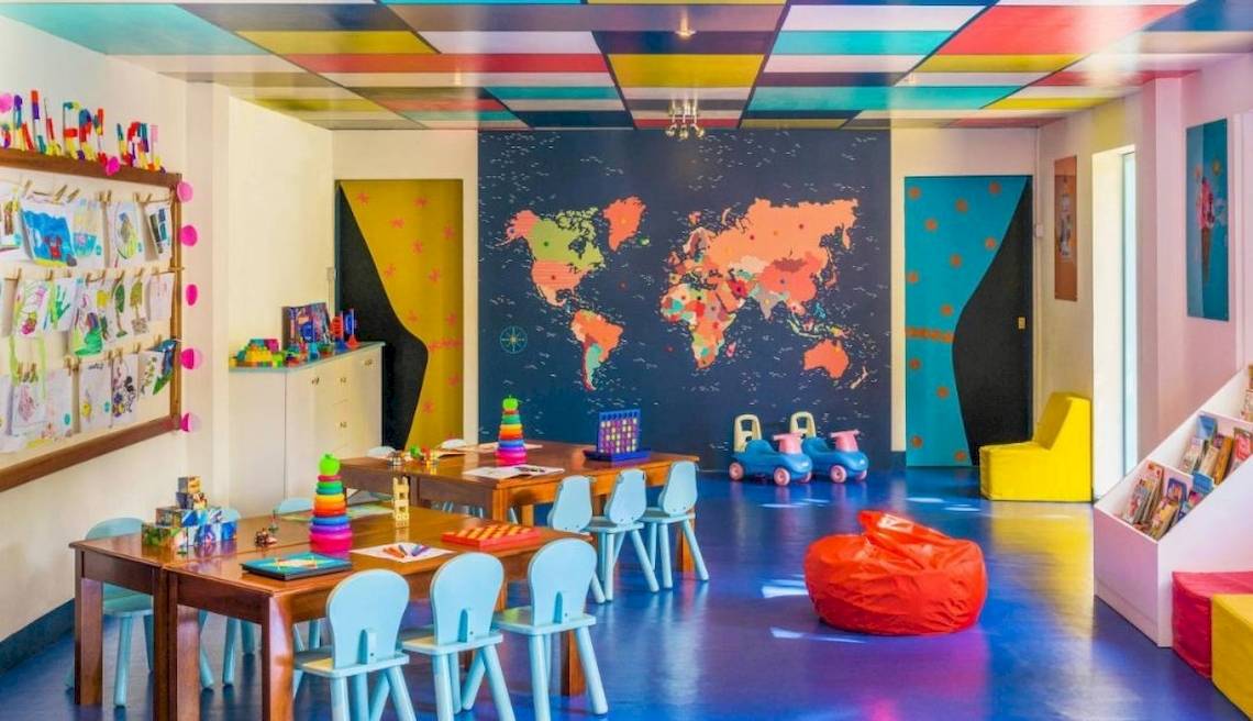 Kinderzimmer im Le Meridien Ile Maurice mit bunten Möbeln und einer Weltkarte an der Wand.