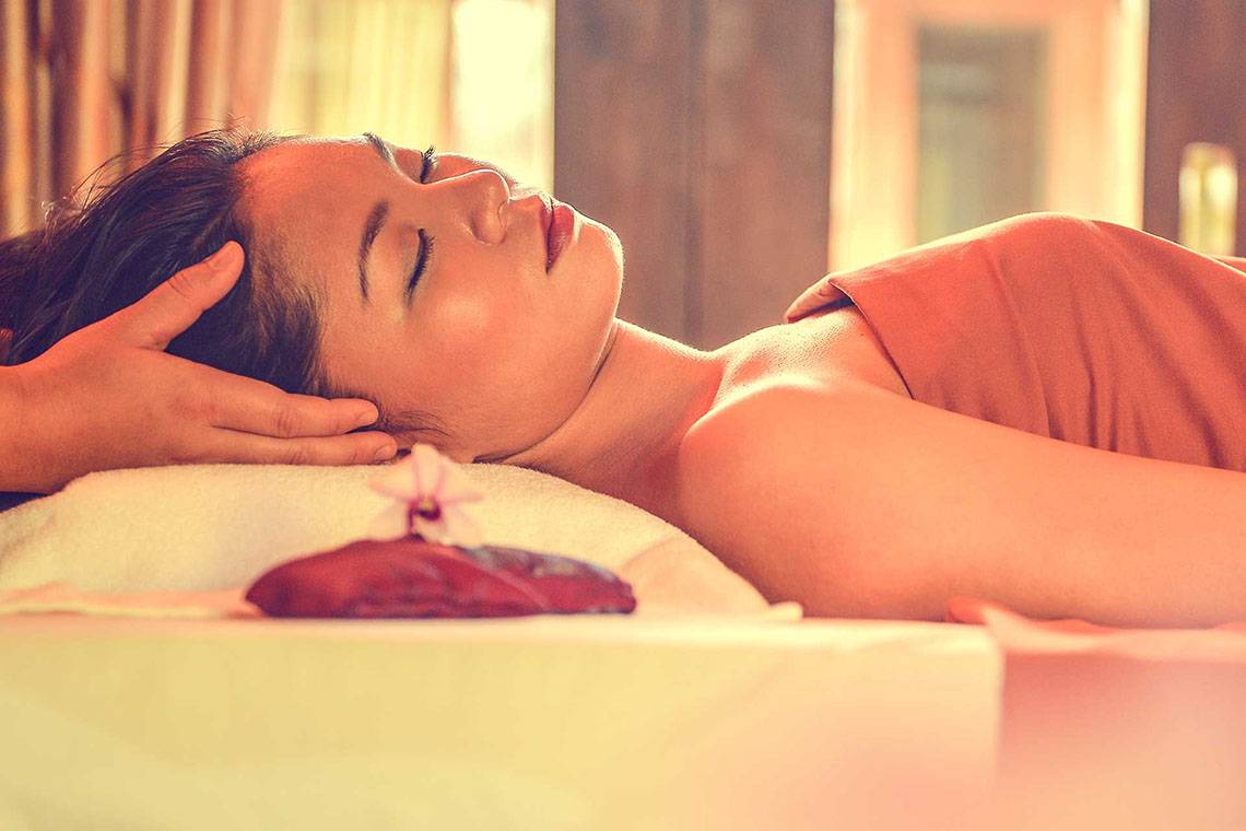 Frau im Hotel Bandos Maldives genießt eine Massage im Spa
