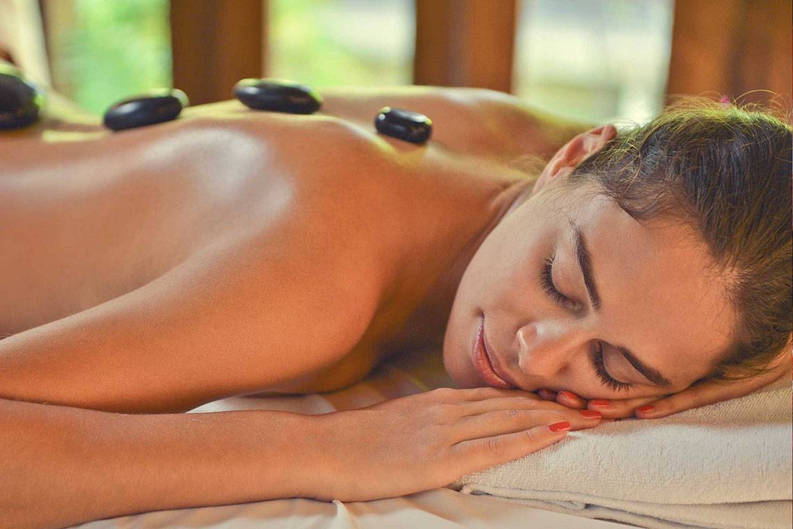 Frau genießt eine Steinmassage im Hotel Bandos Maldives