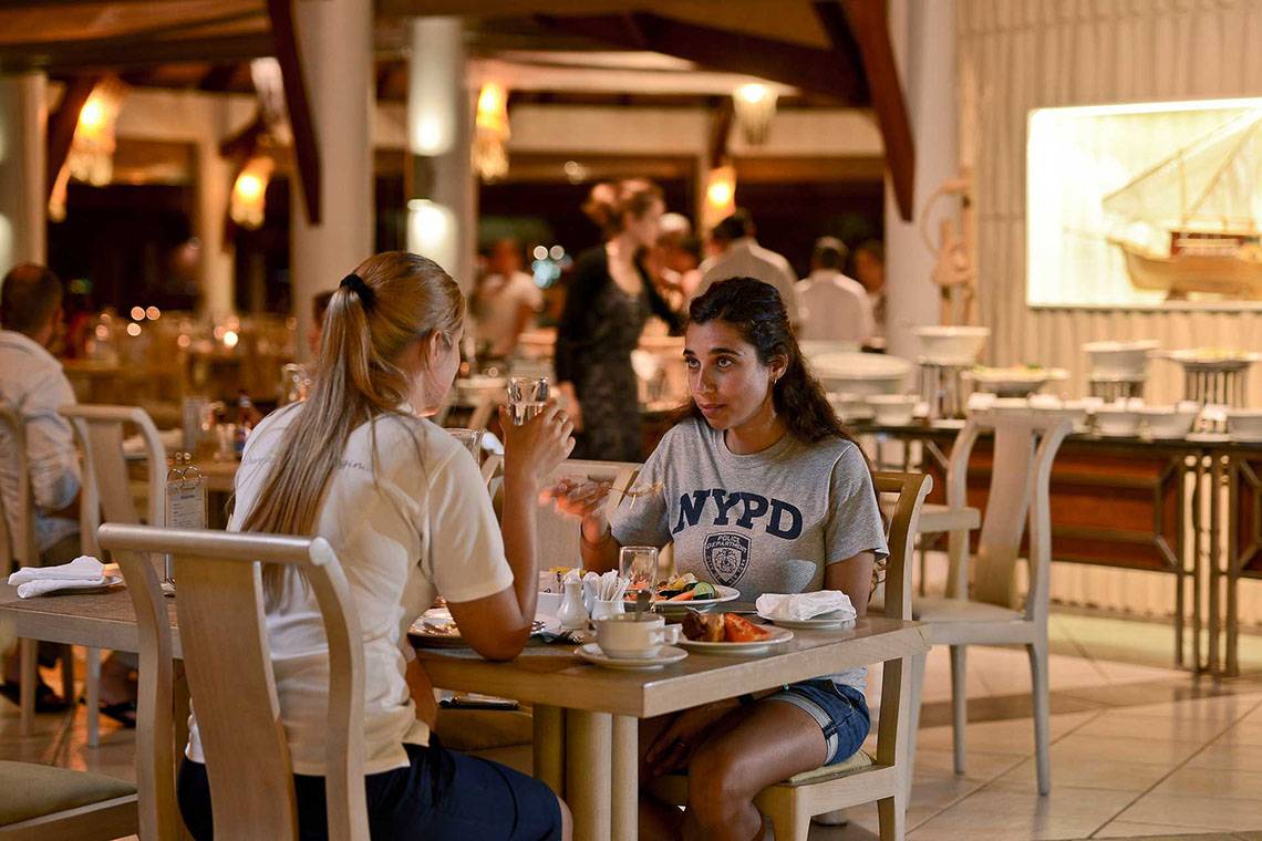 Zwei Frauen essen im Restaurant des Bandos Maldives Hotel.