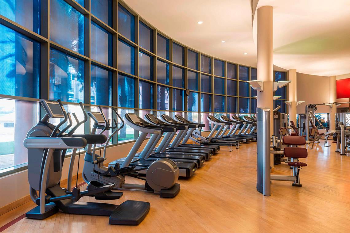 Fitness-Center im Sheraton Abu Dhabi Hotel & Resort mit einer Reihe von Laufbändern und anderen Geräten.