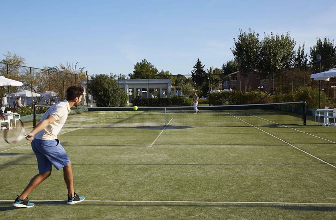 Tennisplatz im Hotel Capo Di Corfu mit Spielern, die Tennis spielen.