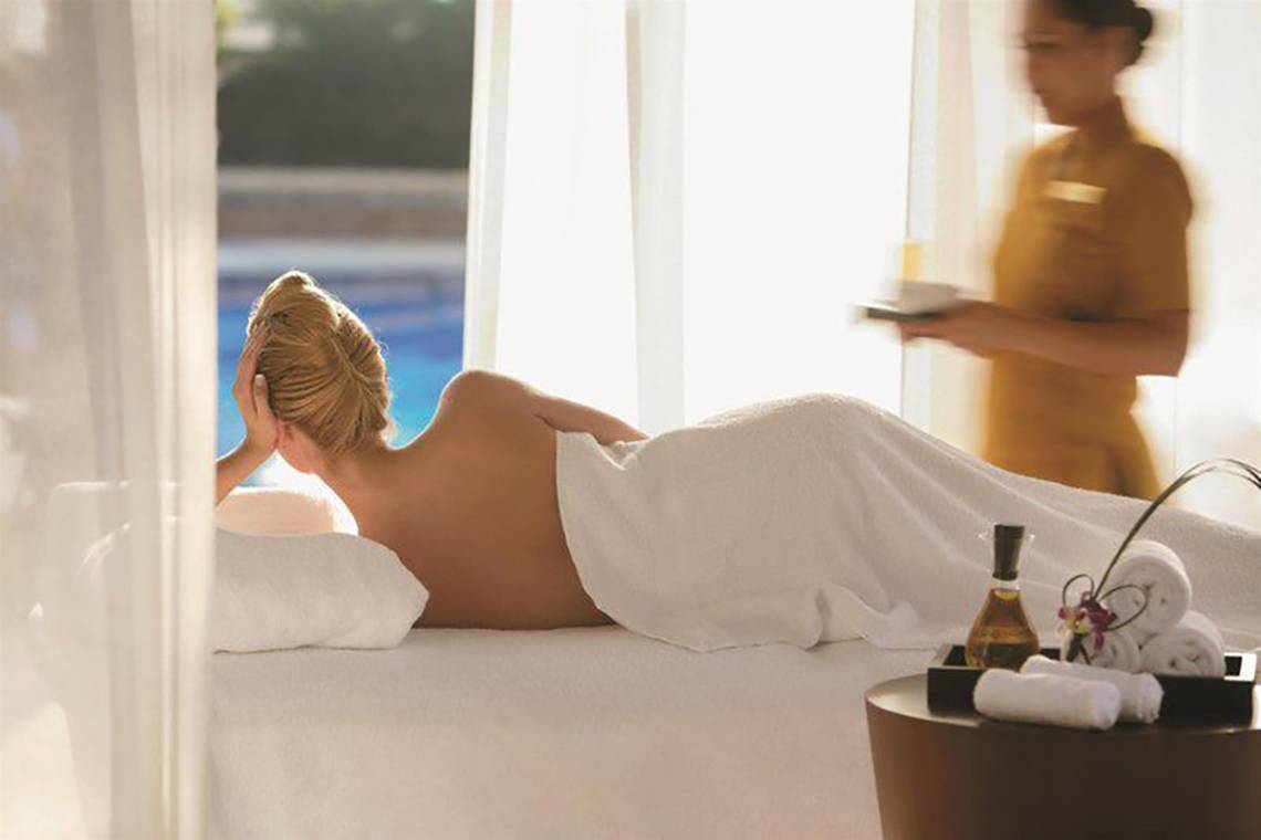 Eine Frau im Wellnessbereich des Hotels Shangri-La Dubai genießt eine Massage.