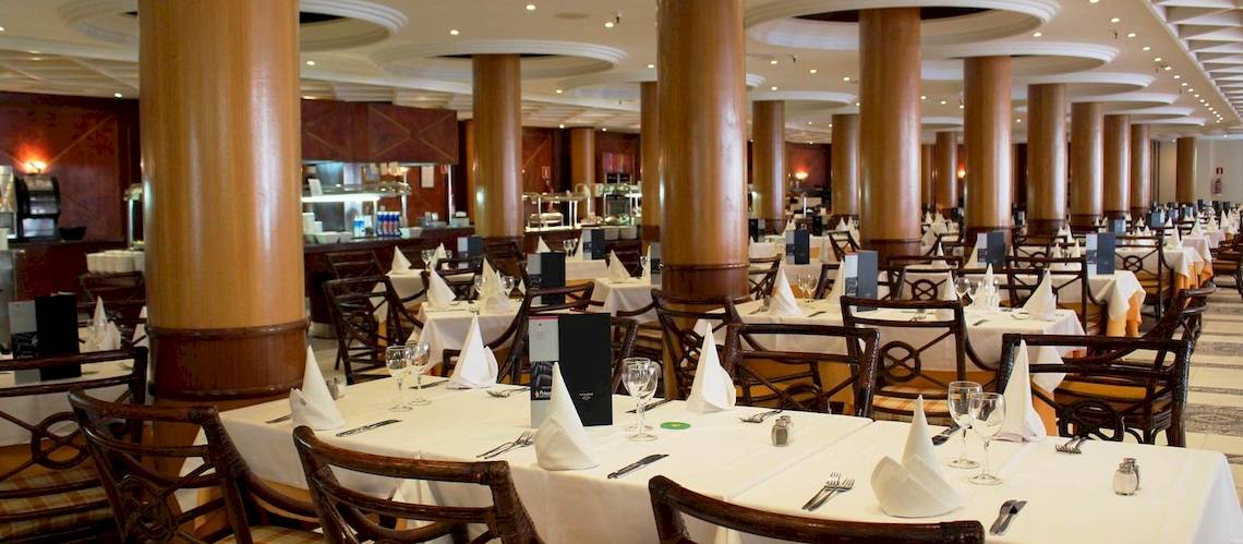 Innenbereich des Princess Inspire Tenerife Hotels mit vielen gedecketen Tischen und Stühlen.