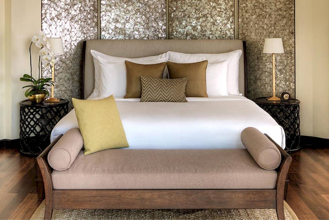 Schlafzimmer im Rayavadee Hotel mit einem großen Bett und mehreren Kissen.