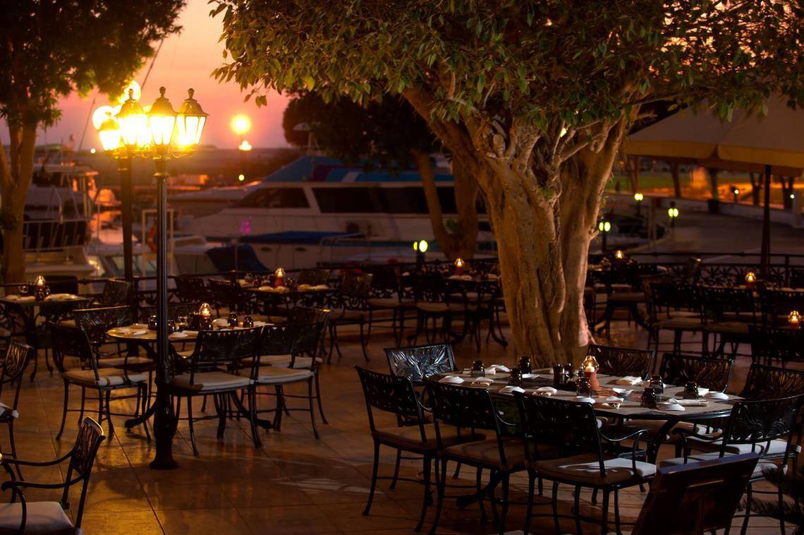Außenbereich des Restaurants des Intercontinental Abu Dhabi mit stimmungsvollen Lampen und Tischen im Freien