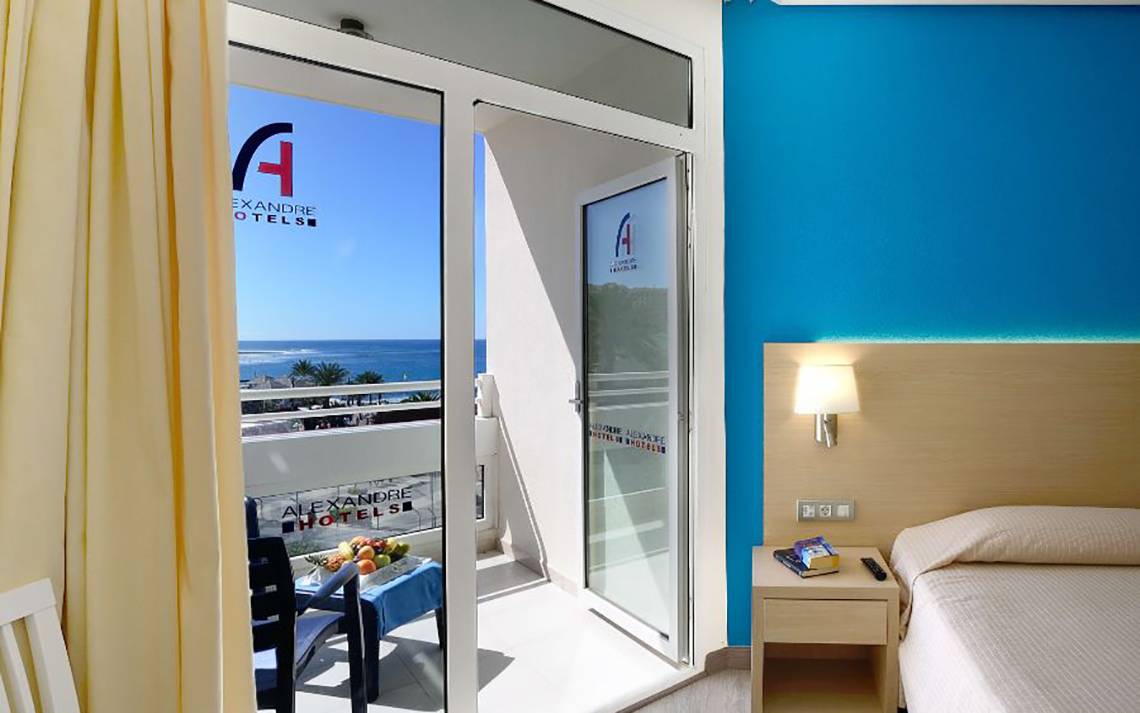 Balkon im Alexandre Hotel Troya mit Blick auf das Meer und blaue Wände.