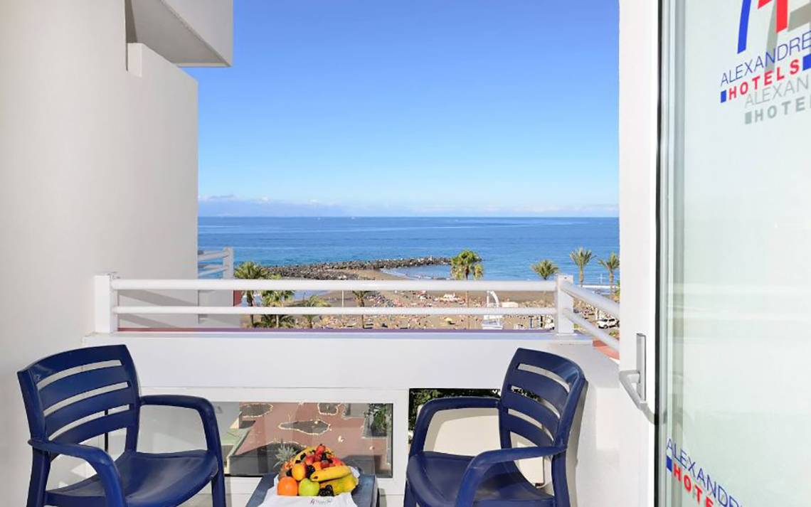 Balkon des Alexandre Hotel Troya mit Blick auf das Meer und eine Obstschale.