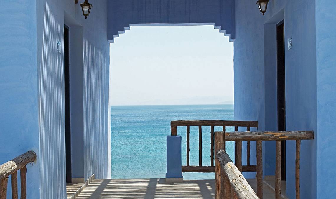 Balkon des Candia Park Village mit Blick auf das Meer und blau gestrichenen Wänden.