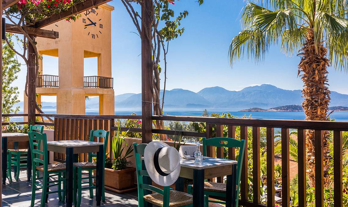 Terrasse des Candia Park Village Hotels mit Blick auf das Meer und die Berge