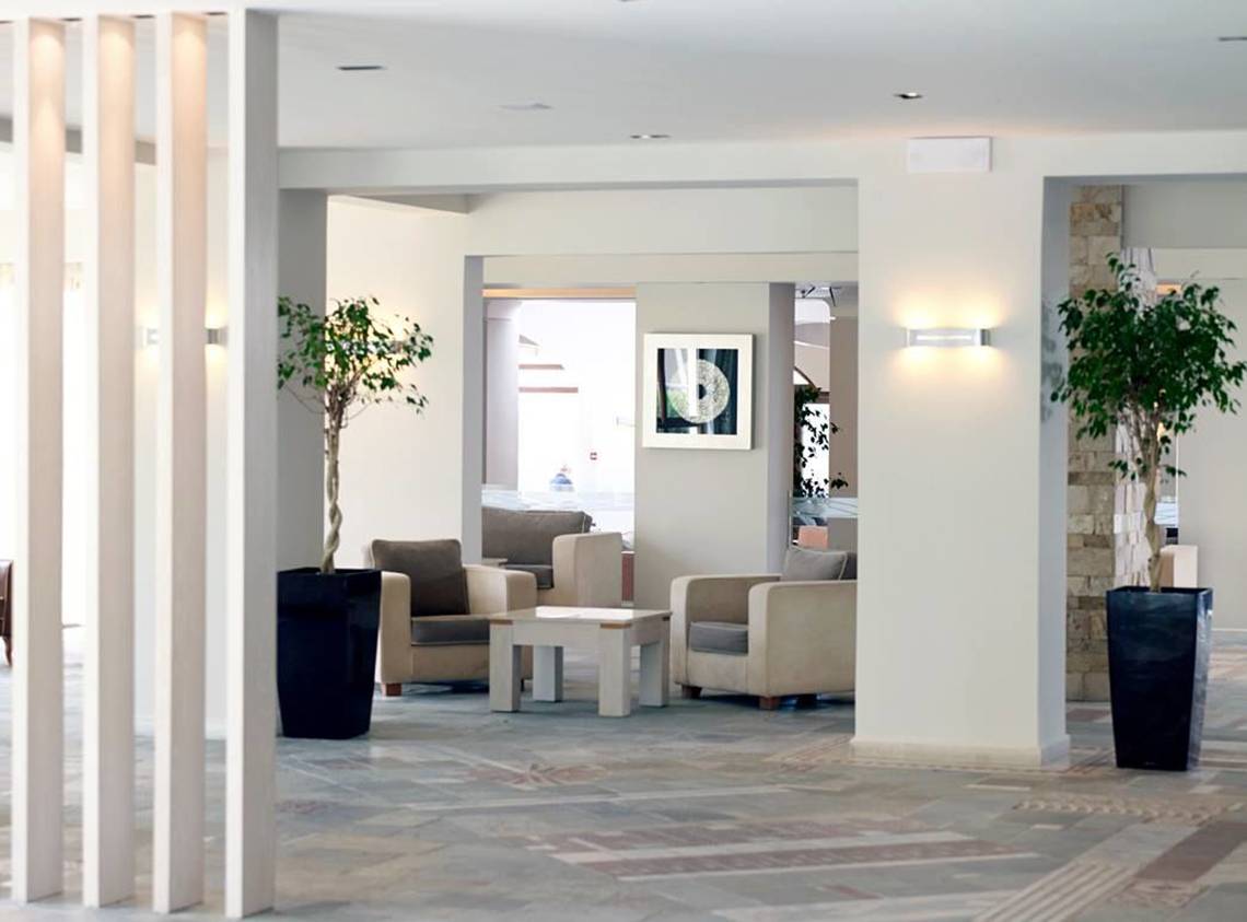 Lobby des Porto Bello Beach Hotels mit Möbeln und Pflanzen.