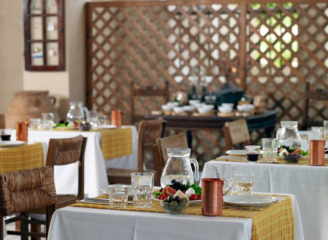 Speisesaal im Porto Bello Beach Hotel mit gedeckten Tischen und Speisen.