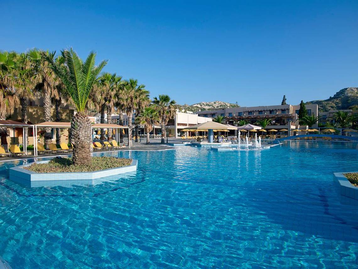 Außenpool des Porto Bello Beach Hotels mit Palmen und Sonnenliegen