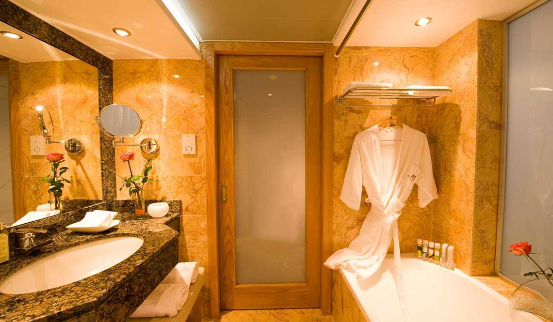 Badezimmer im Pioneer Beach Hotel mit Badewanne, Handtüchern und Toilettenartikeln.