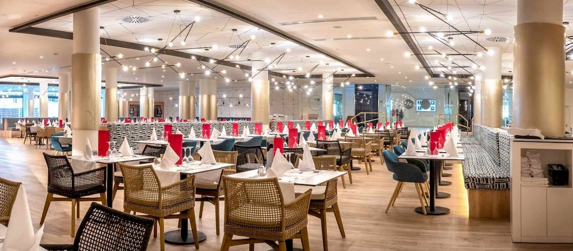 Das Restaurant des Guayarmina Princess Hotels mit gedeckten Tischen und dekorierten Stühlen.