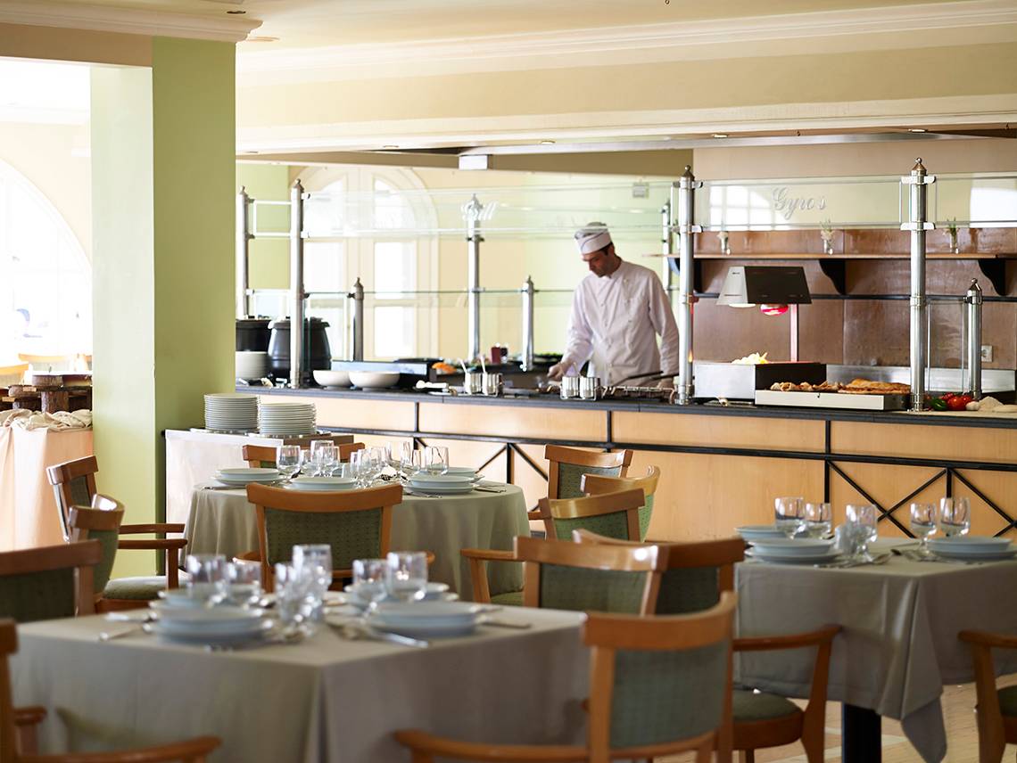 Restaurant im Mitsis Family Village Beach Hotel mit Chefkoch hinter der Theke.