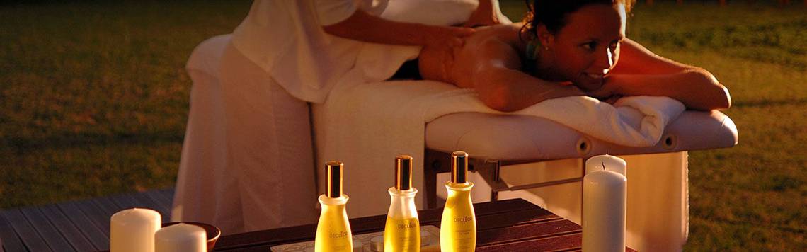 Frau genießt Massage im Freien im Coral Beach Hotel & Resorts