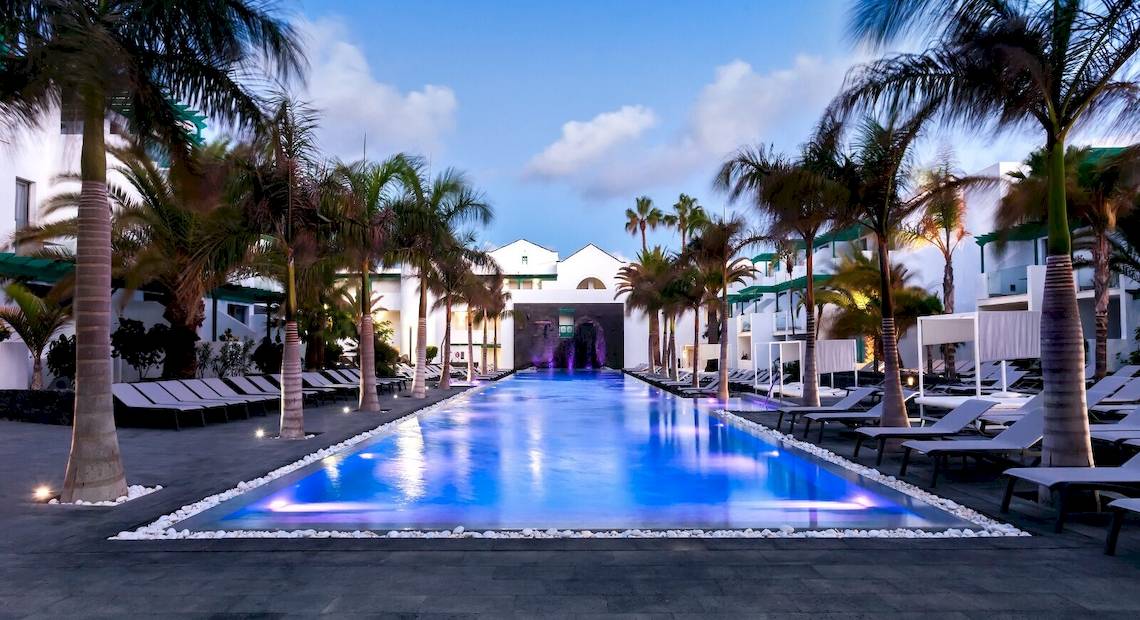 Außenpoolbereich des Barceló Teguise Beach Adults Only Hotel mit Lounge-Stühlen und Palmen