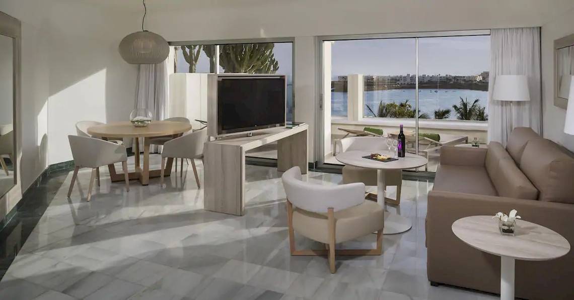Wohnzimmer des Melia Salinas Hotels mit moderner Einrichtung und Meerblick.