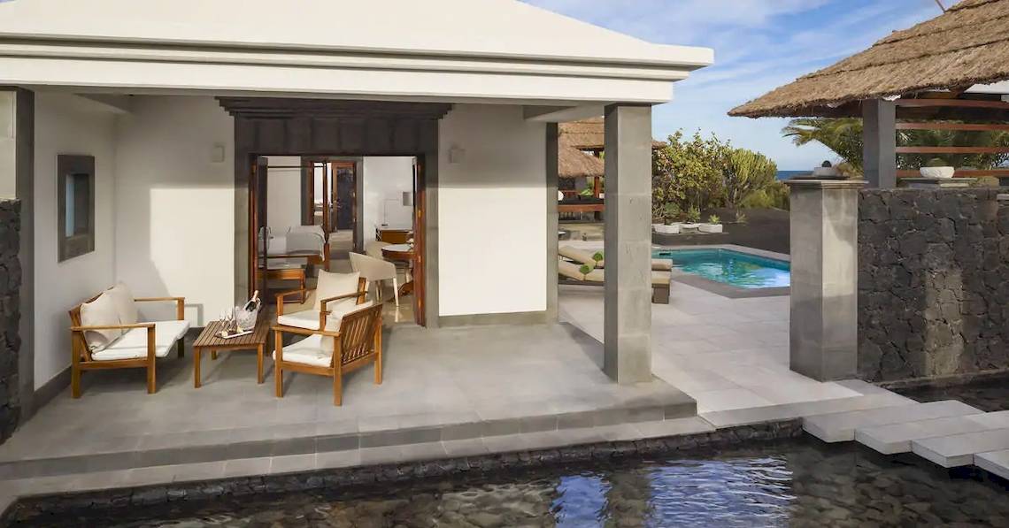 Außenbereich der Melia Salinas Pool Suite mit Terrasse, Möbeln und Pool.