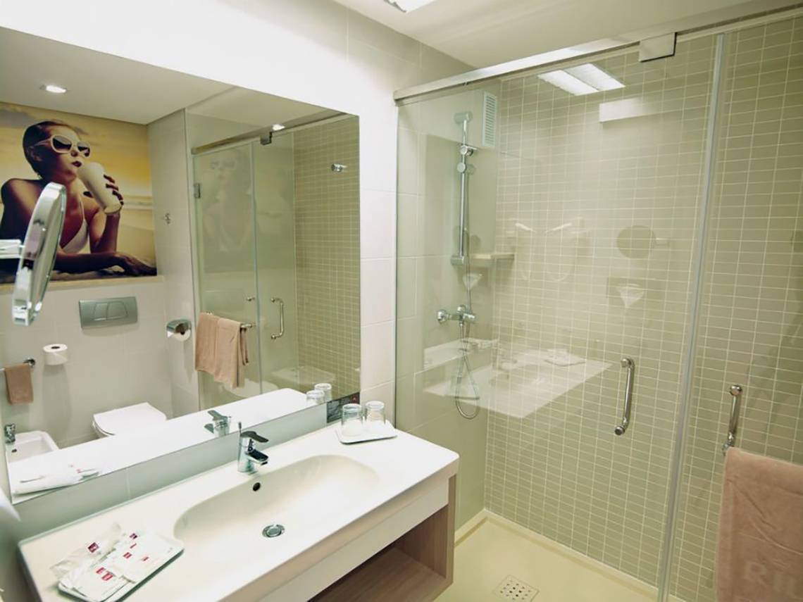 Badezimmer des Riu Gran Canaria Hotels mit Spiegel, Waschbecken, Dusche und Toilette.