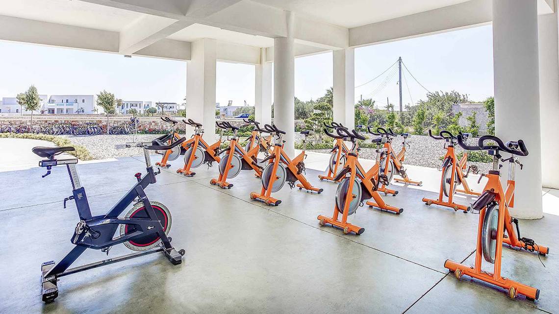 Reihe von orangefarbenen Fahrradtrainern im Freien im Club Plimmiri Hotel.