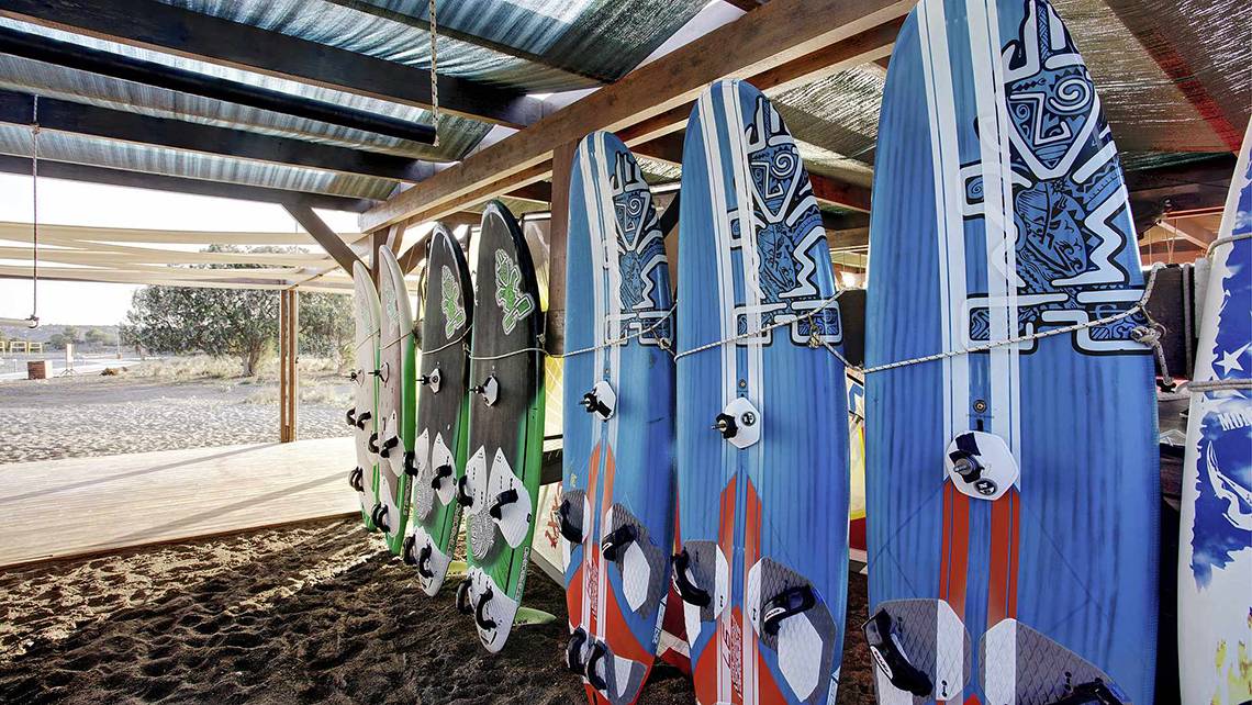 Mehrere Surfbretter mit verschiedenen Designs sind unter einem Dach ausgestellt.
