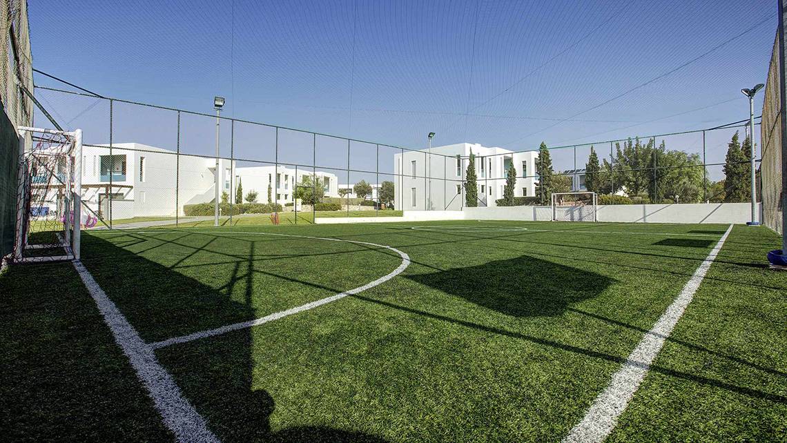 Fussballplatz im Club Plimmiri Hotel mit weißem Zaun und grünem Rasen