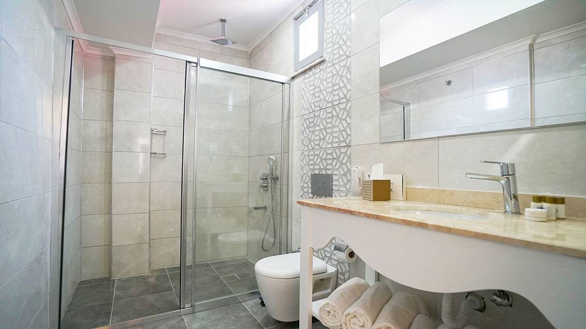 Badezimmer des Selectum Family Comfort Side Hotels mit Dusche, Toilette und Waschbecken.