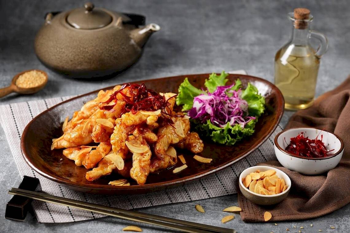 Gebratenes Huhn serviert im Pathumwan Princess Hotel mit Salat und Beilagen.