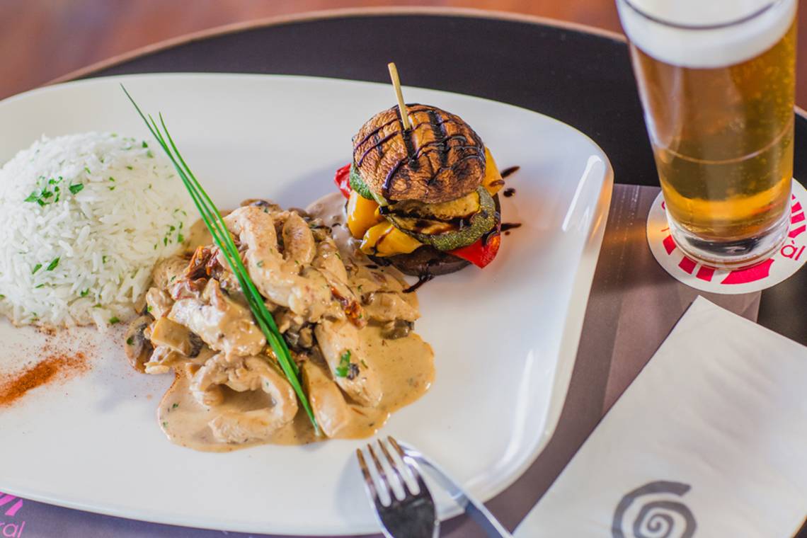 Essen und Getränk im Napa Plaza Hotel: Ein Teller mit Reis, Huhn und einem Burger.