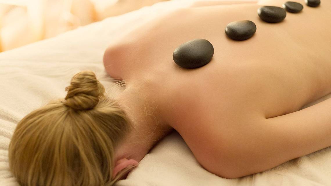 Frau mit Steinen auf dem Rücken im Hotel Massage